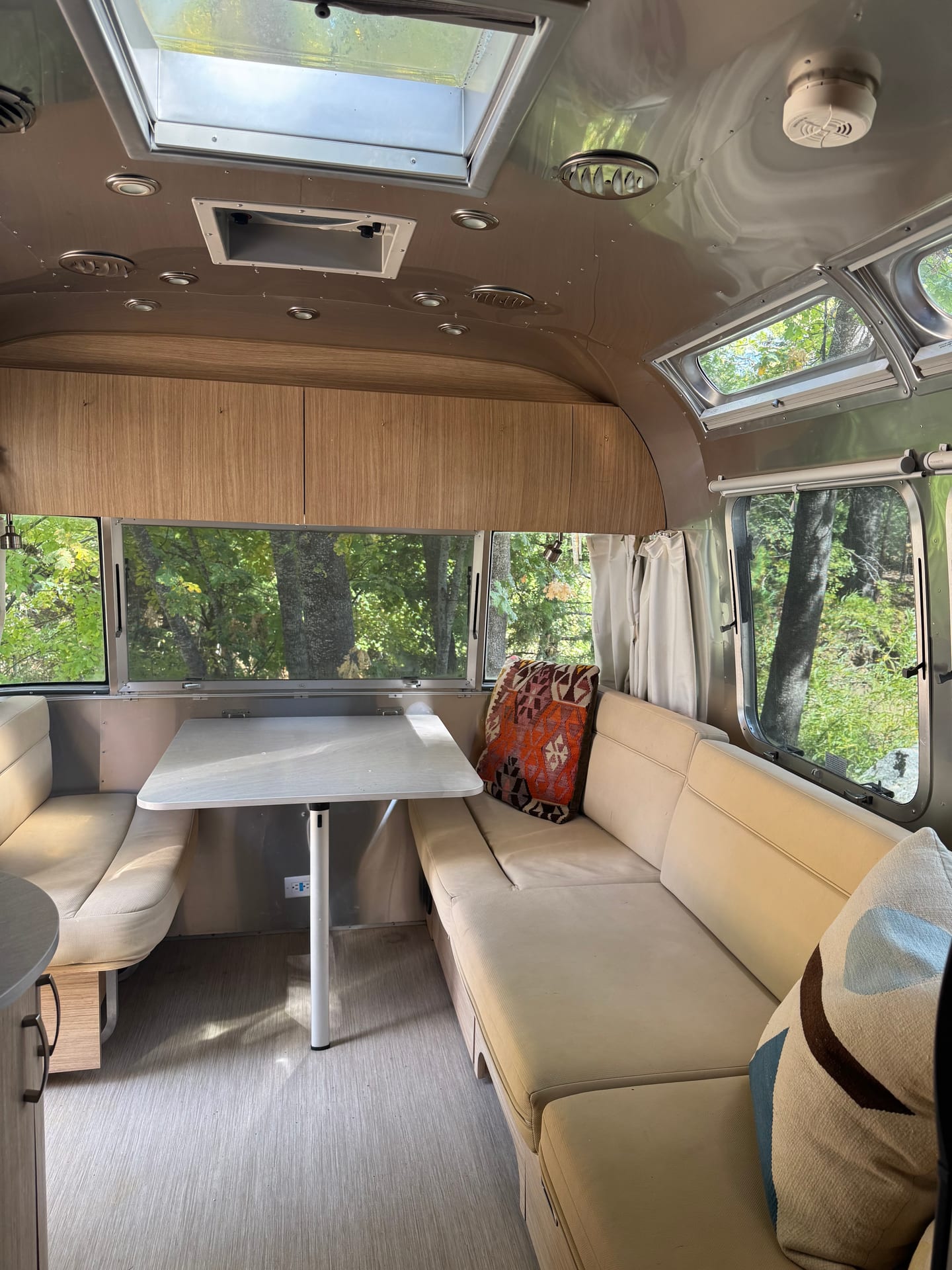 Interior of the 2020 Airstream Flying Cloud at Outdoorsy Yosemite, with dinette, lounge seating and panoramic windows