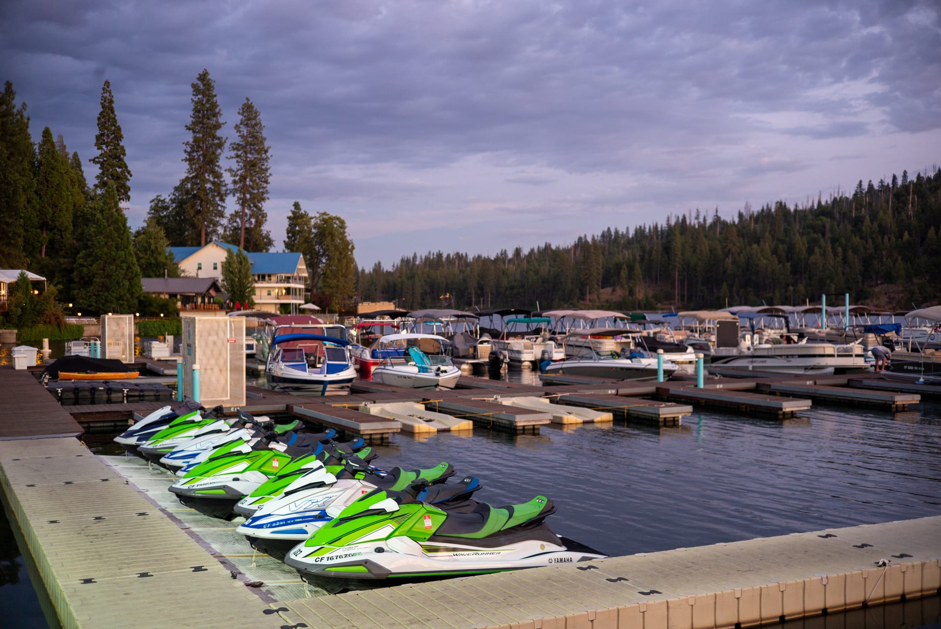 Boats and jet skis docked at Bass Lake Marina at dusk